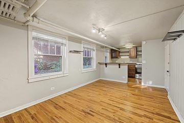 Denver apartment for rent - A room with wooden floors and white walls.