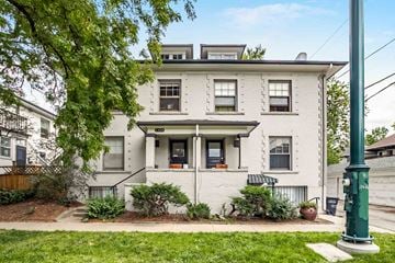 Denver apartment for rent - A white two-story apartment building with a green pole in front.