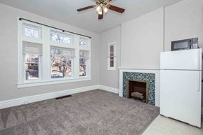 Denver apartment for rent - A living room with a fireplace and a ceiling fan.