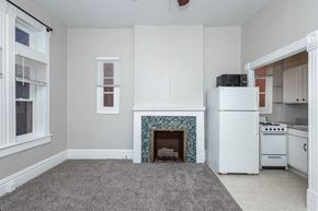 Denver apartment for rent - A white fireplace with a blue border is in the middle of a room.