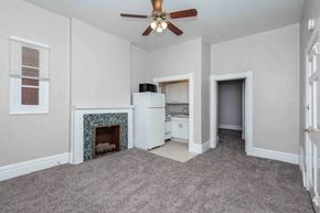 Denver apartment for rent - A room with a fireplace and a ceiling fan.