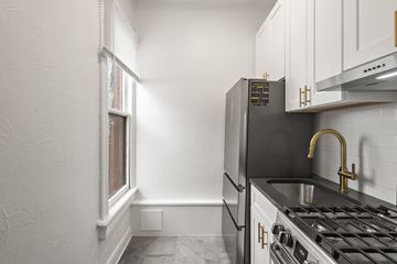 Denver apartment for rent - A kitchen with a black fridge and a black stove top.