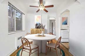 Denver apartment for rent - A white dining table with four chairs and a ceiling fan in a room.