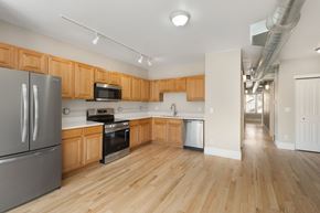 Denver apartment for rent - A kitchen with wooden cabinets and a refrigerator.