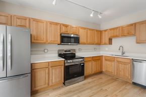 Denver apartment for rent - A kitchen with wooden cabinets and stainless steel appliances.