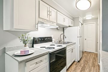Denver apartment for rent - A kitchen with white cabinets and a black stove top.