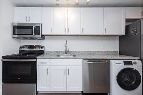 Denver apartment for rent - A modern kitchen with white cabinets and stainless steel appliances.