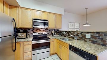 Denver apartment for rent - A kitchen with wooden cabinets and a black refrigerator.