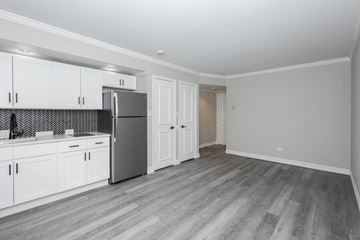 Denver apartment for rent - A kitchen with white cabinets and a grey fridge.