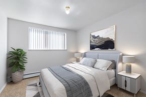 Denver apartment for rent - A bedroom with a bed, nightstand, and a plant.