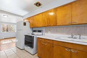 Denver apartment for rent - A kitchen with wooden cabinets and a white fridge.