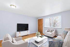 Denver apartment for rent - A living room with a television, two chairs, a sofa, and a coffee table.