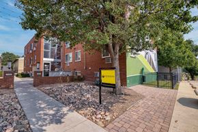 Denver apartment for rent - a yellow sign is in front of a brick building