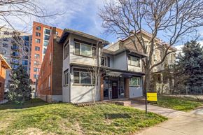 Denver apartment for rent - A two-story house with a yellow sign in front.