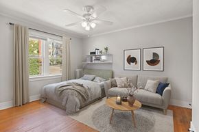 Denver apartment for rent - A bedroom with a bed and a couch with a ceiling fan.