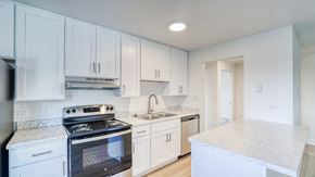 Denver apartment for rent - a kitchen with white cabinets and a stove and a sink