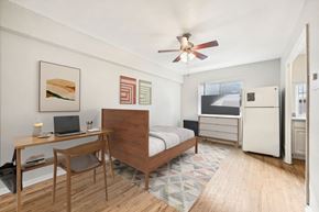 Denver apartment for rent - a bedroom with a bed and a desk and a ceiling fan