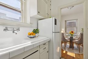 Denver apartment for rent - A kitchen with a white fridge and a bowl of fruit on the counter.