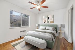 Denver apartment for rent - A bedroom with a bed, a lamp, and a ceiling fan.