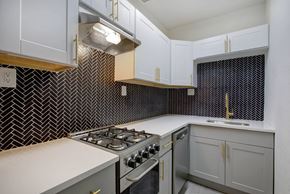 Denver apartment for rent - A kitchen with a stove top oven and a microwave.