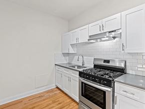 Denver apartment for rent - a kitchen with white cabinets and a stove top oven