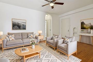 Denver apartment for rent - A living room with a grey sofa, two chairs, a coffee table, and a painting on the wall.