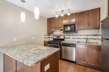 Denver apartment for rent - A kitchen with wooden cabinets and granite countertops.