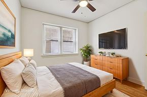 Denver apartment for rent - A bedroom with a bed, dresser, and window.