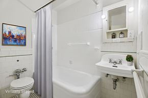 Denver apartment for rent - A white bathroom with a tub, toilet, and sink.