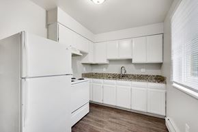 Denver apartment for rent - A white kitchen with a granite countertop and white cabinets.