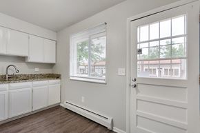 Denver apartment for rent - A kitchen with white cabinets and a granite countertop.