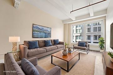 Denver apartment for rent - A living room with a grey couch and a painting of a lake on the wall.