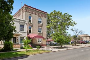 Denver apartment for rent - A building with a red awning is in the foreground of the image.