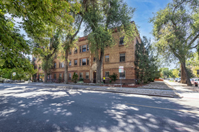 Denver apartment for rent - a brick building with trees in front of it on a street