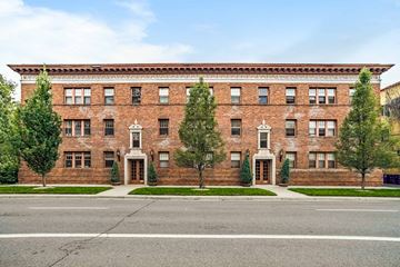 Denver apartment for rent - A large red brick building with a white door and windows.