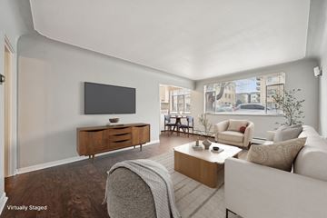 Denver apartment for rent - A living room with a white couch and a wooden coffee table.