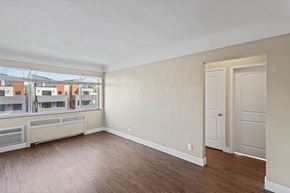 Denver apartment for rent - A room with a wooden floor and white walls.