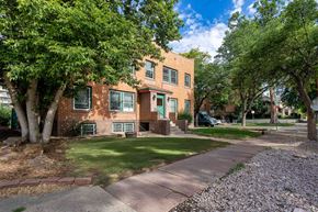 Denver apartment for rent - a brick apartment building with green trees and a sidewalk