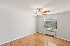 Denver apartment for rent - A room with a ceiling fan and a window with a view of a garden.