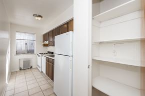 Denver apartment for rent - A kitchen with white appliances and brown cabinets.