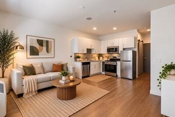 Denver apartment for rent - A modern living room with a white couch and a coffee table in the center.
