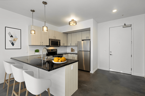 Denver apartment for rent - a kitchen with white cabinets and a black counter top