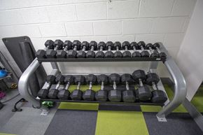 Denver apartment for rent - A set of dumbbells are arranged on a rack in a gym.