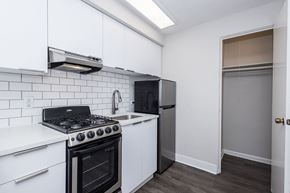 Denver apartment for rent - A kitchen with white cabinets and a black stove top oven.
