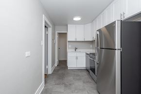 Denver apartment for rent - A kitchen with a refrigerator on the right and a sink in the middle.