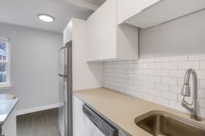 Denver apartment for rent - A kitchen with a stainless steel sink and white cabinets.