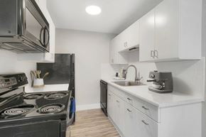 Denver apartment for rent - a white kitchen with black appliances and white cabinets