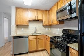 Denver apartment for rent - A kitchen with wooden cabinets and black appliances.