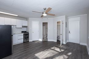 Denver apartment for rent - A kitchen with a black fridge and wooden floors.