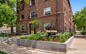Denver apartment for rent - A brick building with a yellow door and a sign that says "Poets Row".